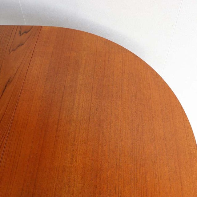 Round vintage teak dining table top with smooth wood grain and warm mid-century British-Danish design.