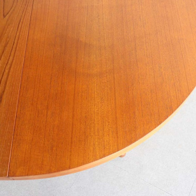Round mid-century Edward Valentinsen dining table in teak with visible wood grain and smooth finish.