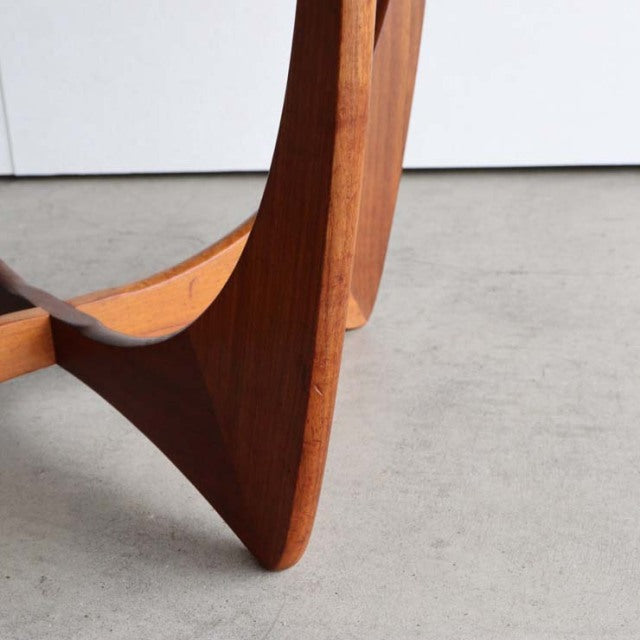 Close-up of teak wood leg on vintage mid-century British G-plan Astrol round coffee table with sculpted grain and smooth.