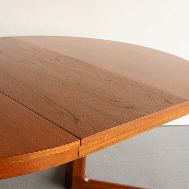Vintage teak round dining table by Edward Valentinsen with smooth wood grain and mid-century British-Denmark design.