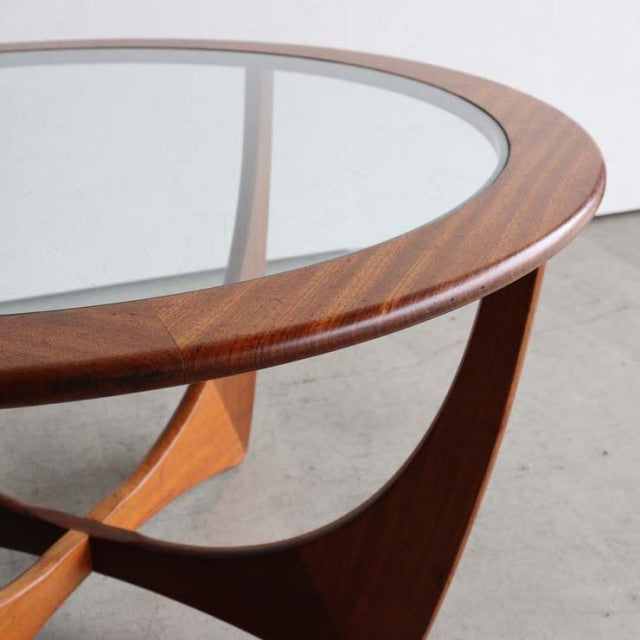 Mid-century British G-Plan Astroland round coffee table with teak wood frame and clear glass top, showcasing elegant curved.