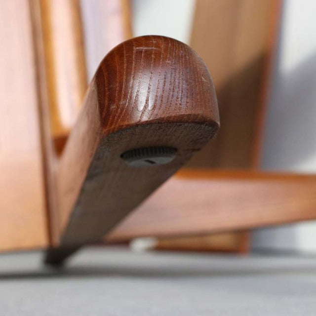 Close-up of vintage teak dining table leg in British mid-century Danish design, showcasing smooth wood grain and rounded.