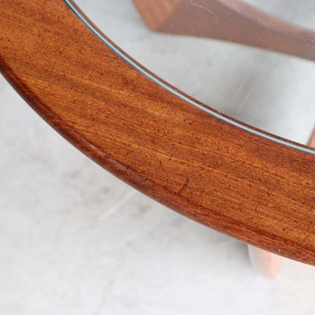 Mid-century British G-PLAN Astrolound teak coffee table with round glass top and visible wood grain.