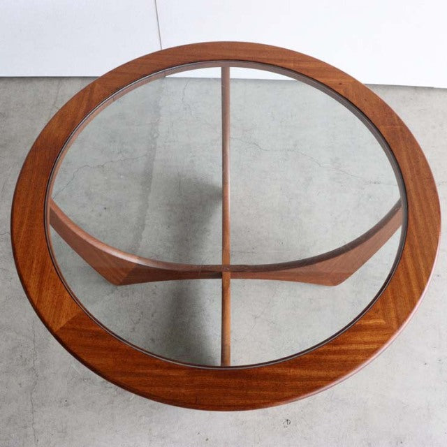 Vintage British G-Plan mid-century teak coffee table with round glass top and sculpted legs.