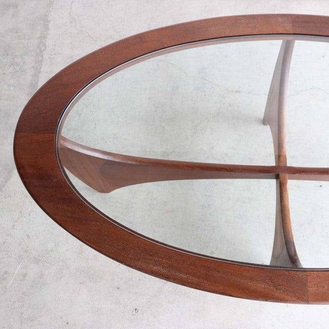 Oval mid-century British G-Plan coffee table with teak frame, clear glass top, and tapered legs.