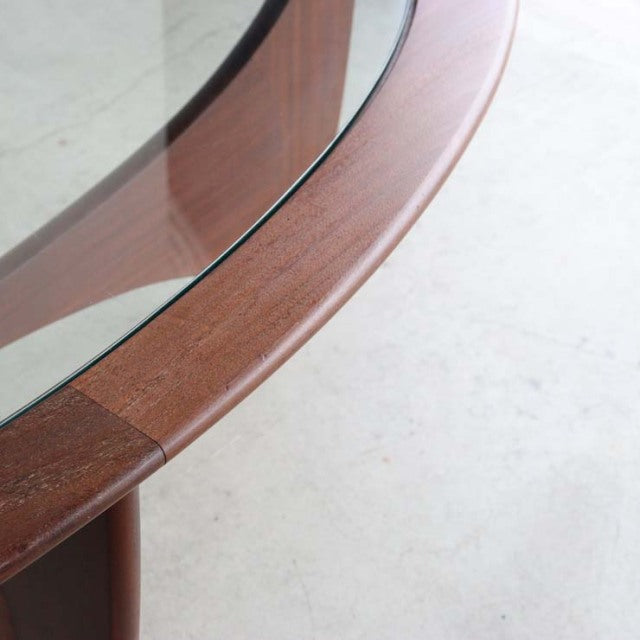 Oval glass top coffee table with mid-century teak frame showing rich wood grain and smooth rounded edges, British vintage.