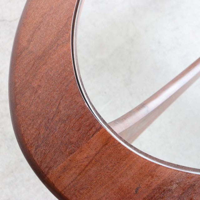 Oval vintage teak coffee table with glass top and visible fine wood grain, mid-century British design.