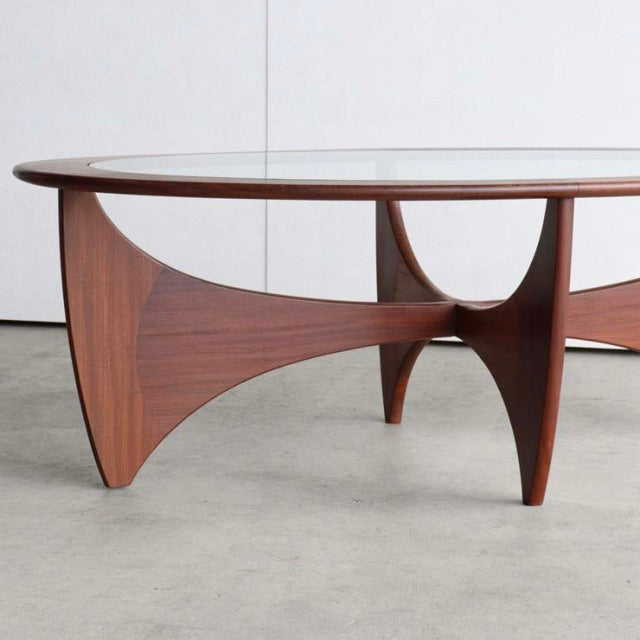 Mid-century British vintage G-Plan teak coffee table with oval glass top and sculpted wood legs.