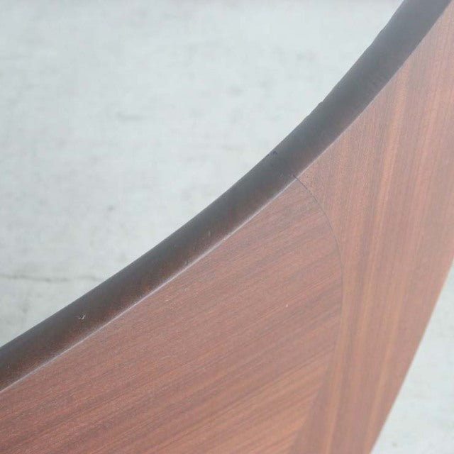 Close-up of vintage G-plan teak coffee table edge showing smooth oval glass top and rich wood grain detailing on mid-century .