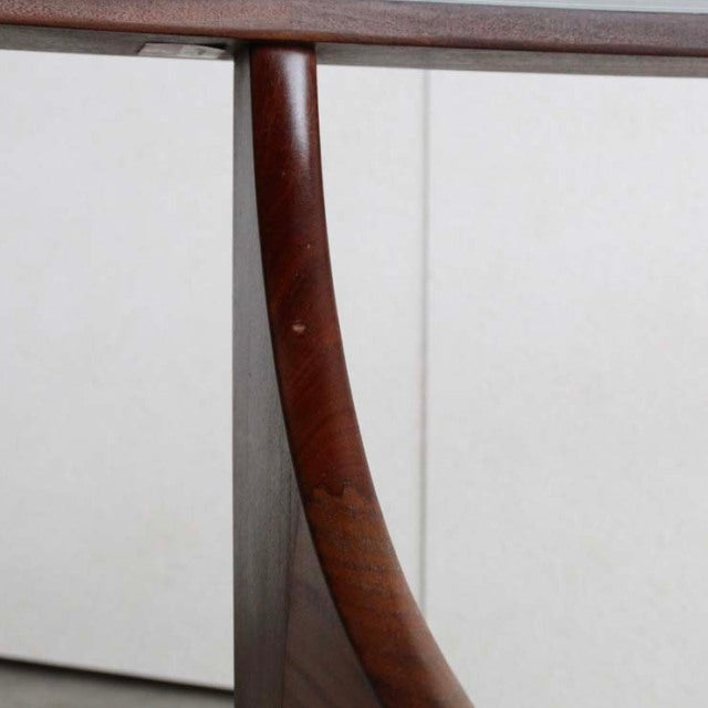 Mid-century British G-Plan teak coffee table leg with visible wood grain and curved support detail.