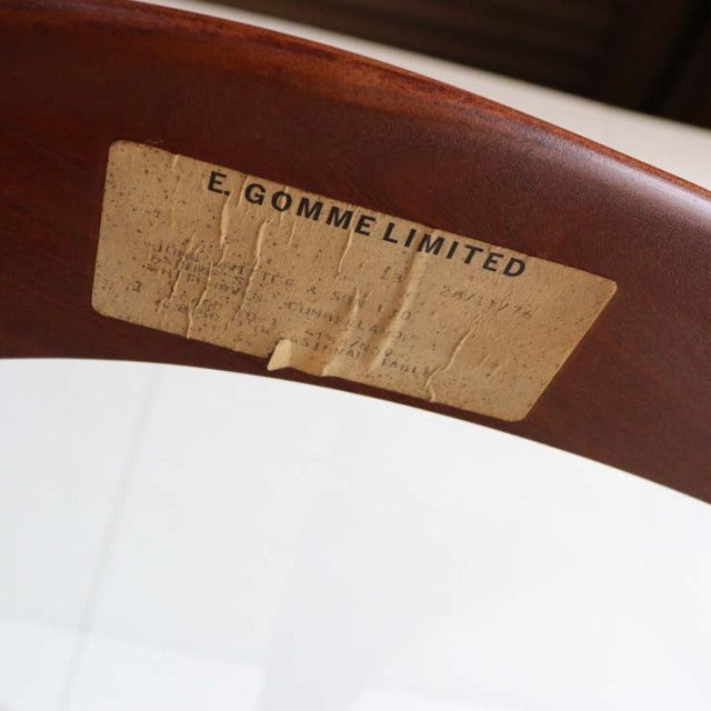 Oval mid-century British teak coffee table with glass top, showcasing rich wood grain and smooth rounded edges.