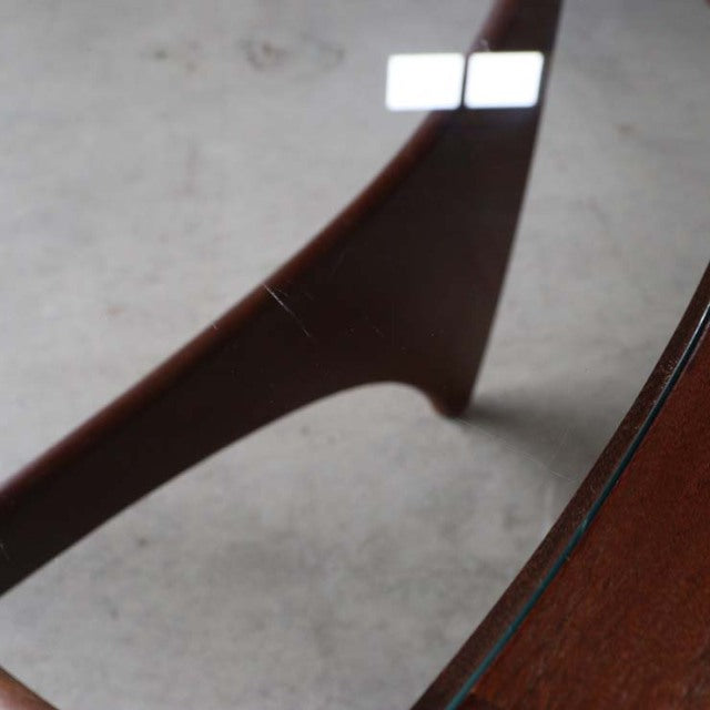 Mid-century British G-Plan teak coffee table leg with smooth wood grain and tapered angled design under oval glass top.