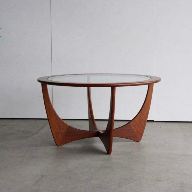 Vintage mid-century British G-Plan Astro round coffee table with glass top and teak wood frame featuring smooth curved legs.