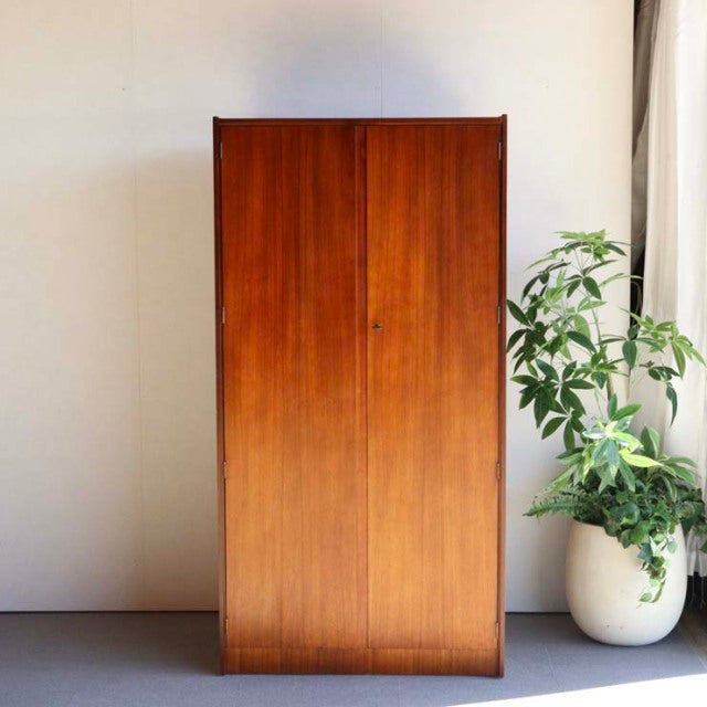 Vintage mid-century teak wardrobe by William Laurence with sleek British design, rich wood grain, and tapered legs.