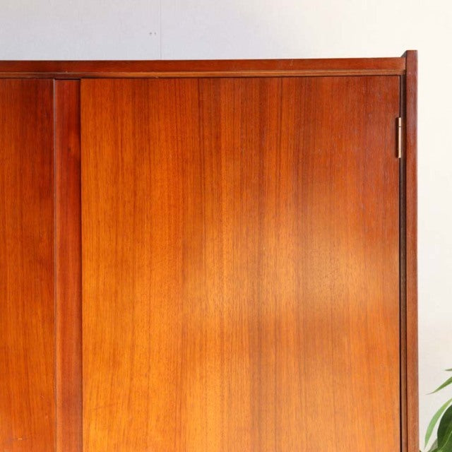Vintage mid-century British teak cabinet by William Laurence, smooth wood grain, clean lines, slender vertical panel detail, .