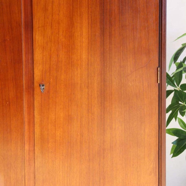 Vintage mid-century teak wardrobe by William Laurence showcasing rich wood grain, British-Denmark design with sleek vertical .