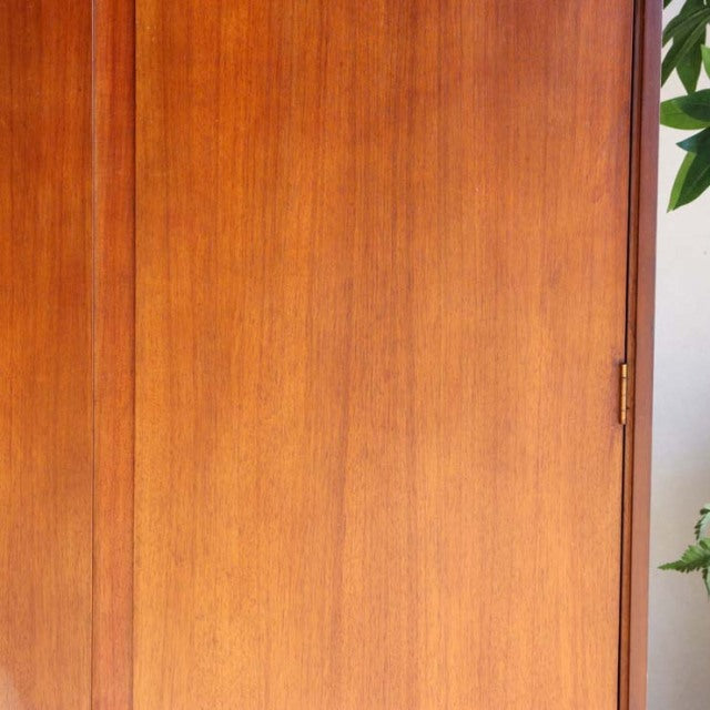 Vintage mid-century teak wardrobe by William Laurence, British design with smooth wood grain and brass hinge detailing.