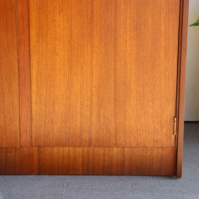 Vintage mid-century teak cabinet with smooth wood grain, slim vertical panels, and clean British design lines.