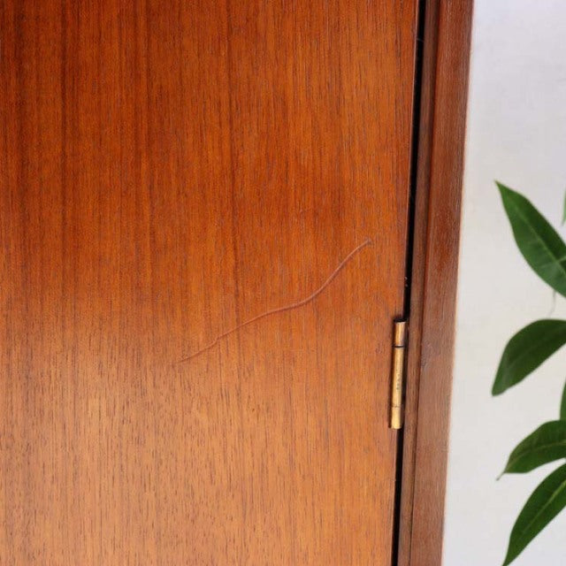 Close-up of vintage teak wood cabinet door with rich grain texture, brass hinge, and smooth mid-century British design from.