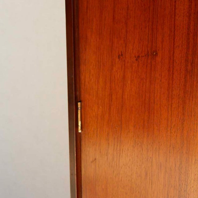 Close-up of vintage teak wood cabinet door from British mid-century William Laurence wardrobe, showing smooth grain and.