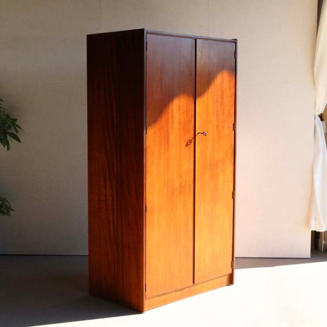 Vintage mid-century teak wardrobe by William Laurence with clean lines, visible wood grain, and slender legs in.