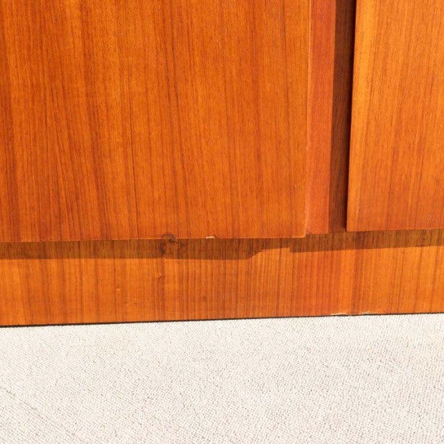 Close-up of vintage teak wood grain and lower panel of British mid-century cabinet by William Laurence with smooth finish.