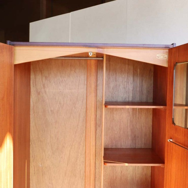 Vintage mid-century teak wardrobe by William Laurence, British design with natural wood grain, open door showing interior.
