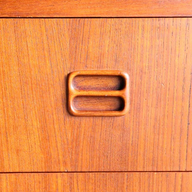 Close-up of vintage teak bureau drawer showing smooth wood grain and Danish mid-century rectangular recessed handle by.