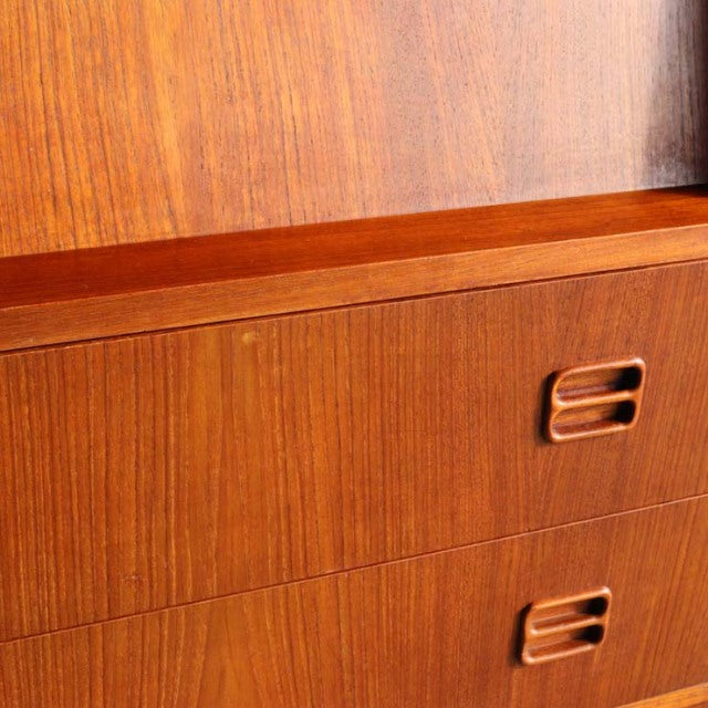 Close-up of vintage teak bureau showing rich wood grain and recessed British-style drawer handles, mid-century Denmark.