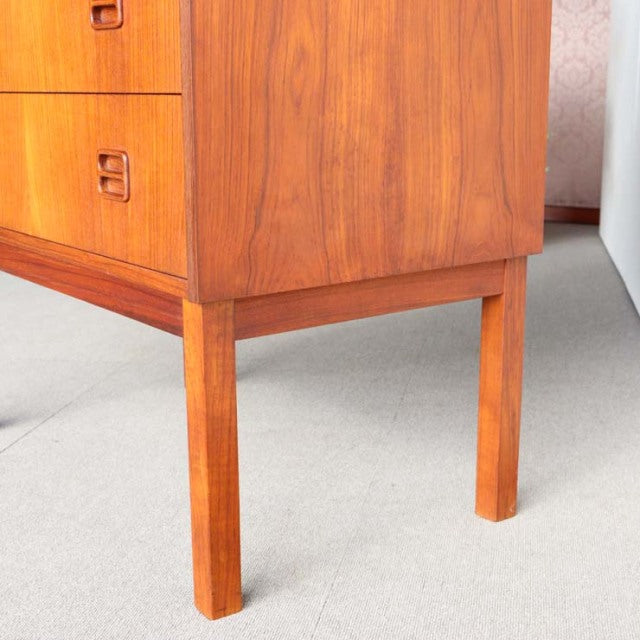 Mid-century teak bureau leg detail showing warm wood grain and clean-lined Danish craftsmanship.