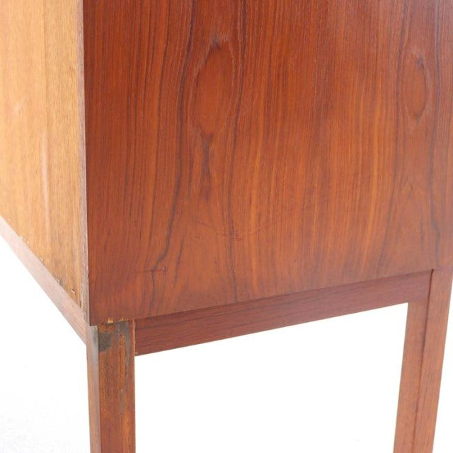 Close-up of vintage teak mid-century bureau leg and rich wood grain, showcasing Danish craftsmanship by Gunnar Nielsen.