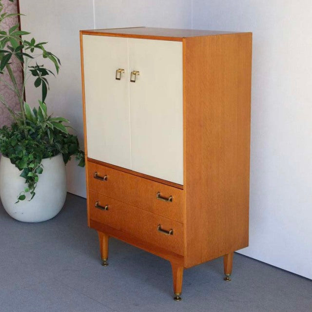 Vintage mid-century G-Plan teak cabinet with oak front, tapered legs, brass handles, and clean British-Scandinavian design.