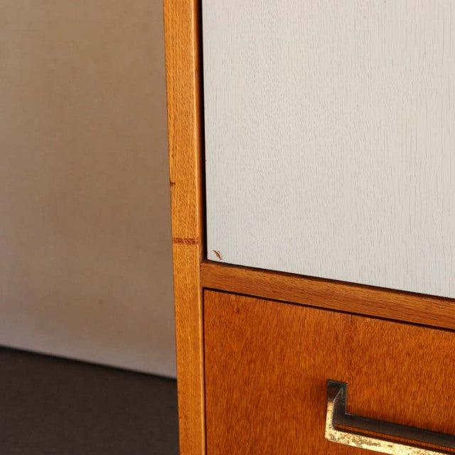 Close-up of vintage British G-PLAN teak cabinet corner showing warm wood grain and brass handle detail on mid-century.