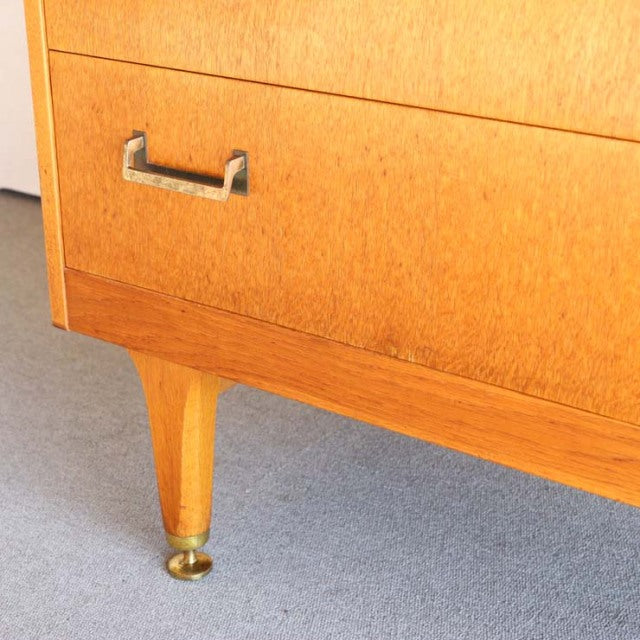 Mid-century British G-PLAN tallboy cabinet in vintage teak with visible wood grain, tapered legs, and brass feet.