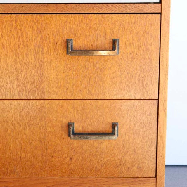 Mid-century British G-PLAN teak cabinet drawers with wood grain and metal handles, vintage tallboy style.