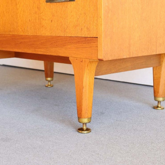 Mid-century vintage British teak cabinet leg with brass-tipped foot, showcasing wood grain and Danish design influence.