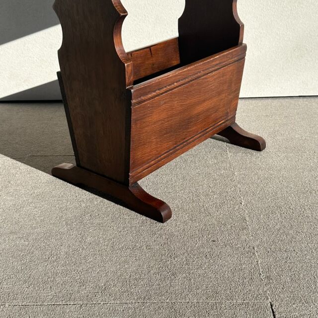 Vintage teak wood British mid-century magazine rack with curved sides and smooth grain finish.