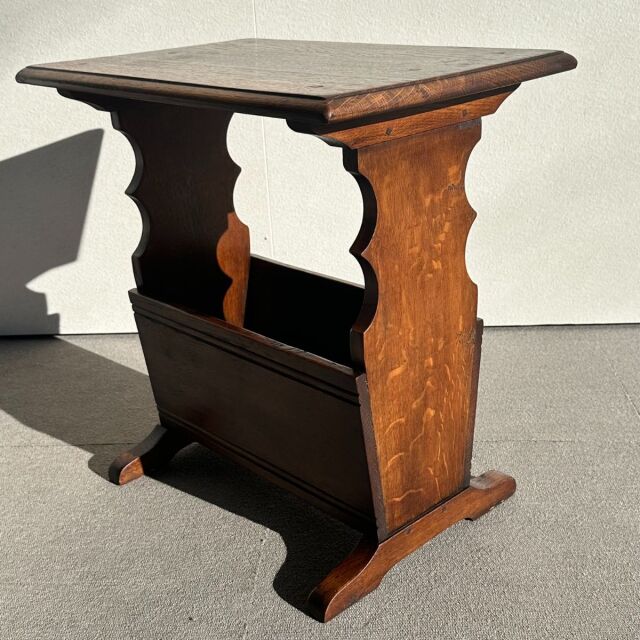 Vintage British teak mid-century side table with scalloped panel sides and rich wood grain.