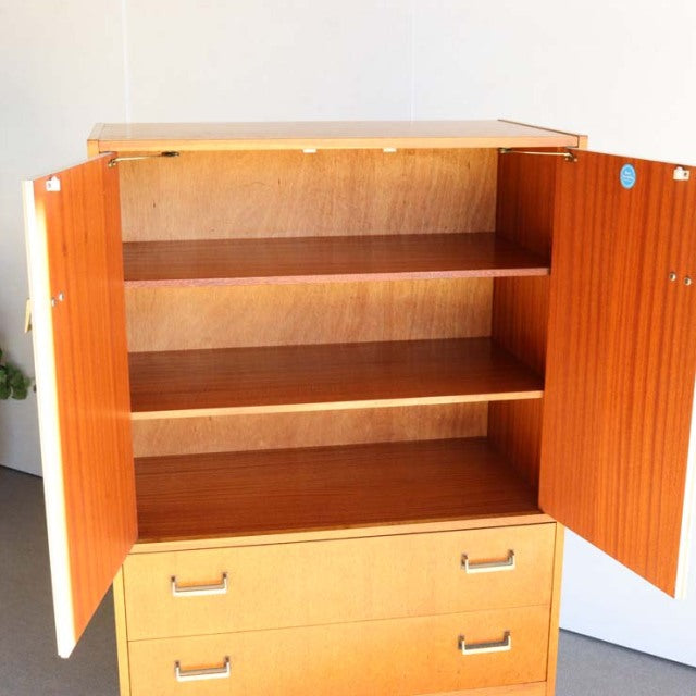 Vintage British mid-century teak G-Plan tallboy cabinet with open doors showing wood grain and two drawers.