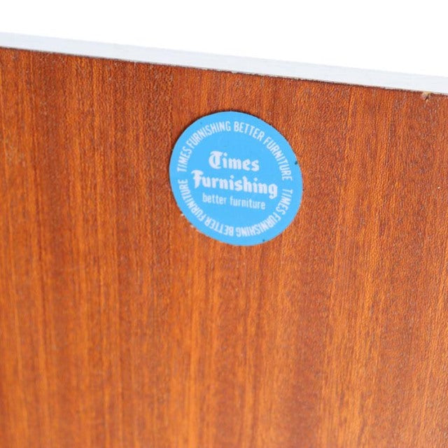 Close-up of vintage teak wood grain on British mid-century G-PLAN cabinet with blue circular Times Furnishing label from.
