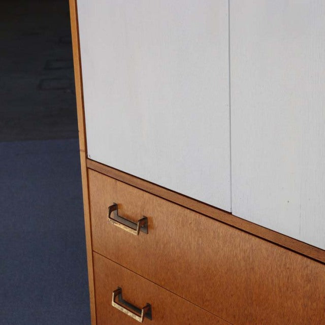 Vintage teak G-Plan tallboy cabinet with rich wood grain, brass handles, and mid-century British design influences.