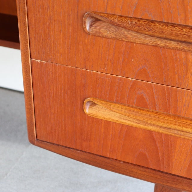 Vintage British mid-century teak desk drawers with rounded wood handles and visible wood grain.