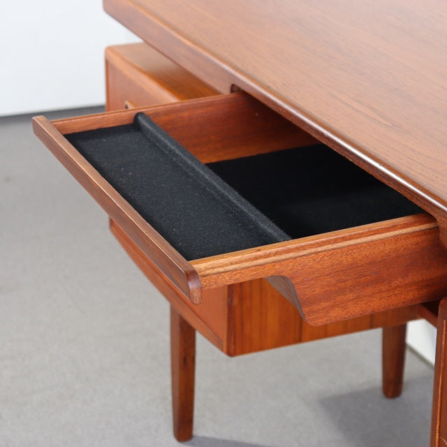 Vintage British mid-century teak G-PLAN desk drawer open showing sleek wood grain and black felt lining with tapered legs.
