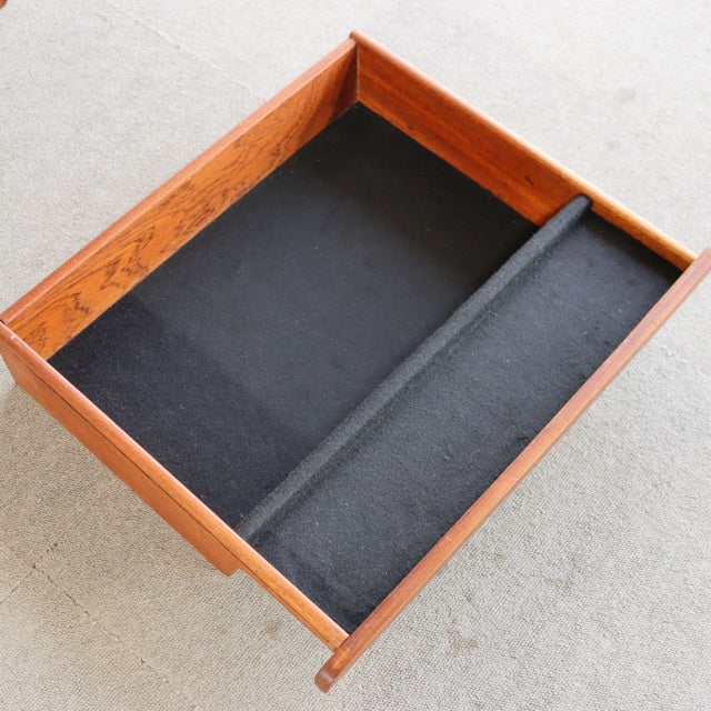 Open teak drawer from mid-century British G-PLAN desk with black felt lining and internal divider.