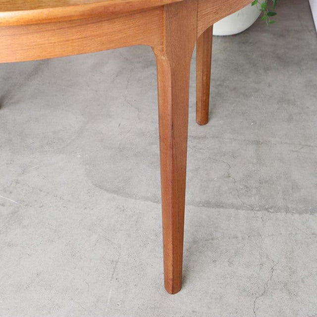 Mid-century British vintage teak dining table leg with smooth wood grain and tapered design.