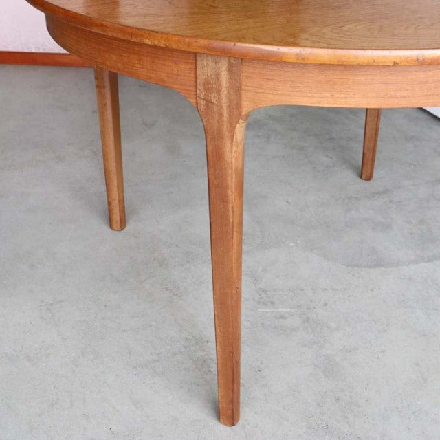 Vintage teak NATHAN mid-century British dining table leg with smooth grain and tapered design on concrete floor.