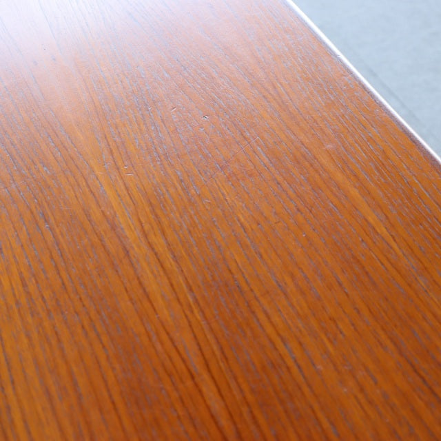 Close-up of vintage British mid-century teak desk surface showing fine wood grain and smooth finish.