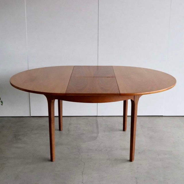 Vintage mid-century teak dining table by Nathan with oval British design and tapered legs.
