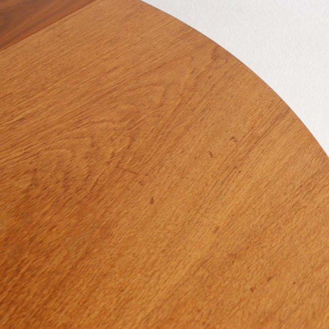 Round vintage teak dining table top showing warm wood grain with smooth finish, mid-century British design.