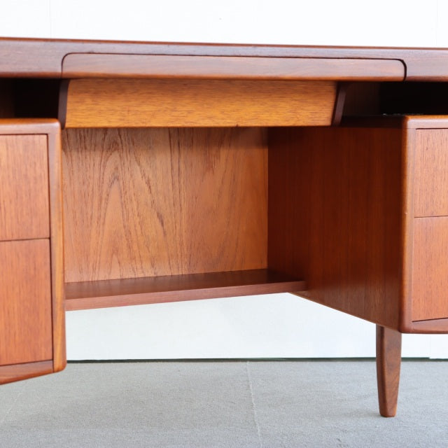 Vintage mid-century teak G-PLAN desk with visible wood grain, tapered legs, and open storage compartments.